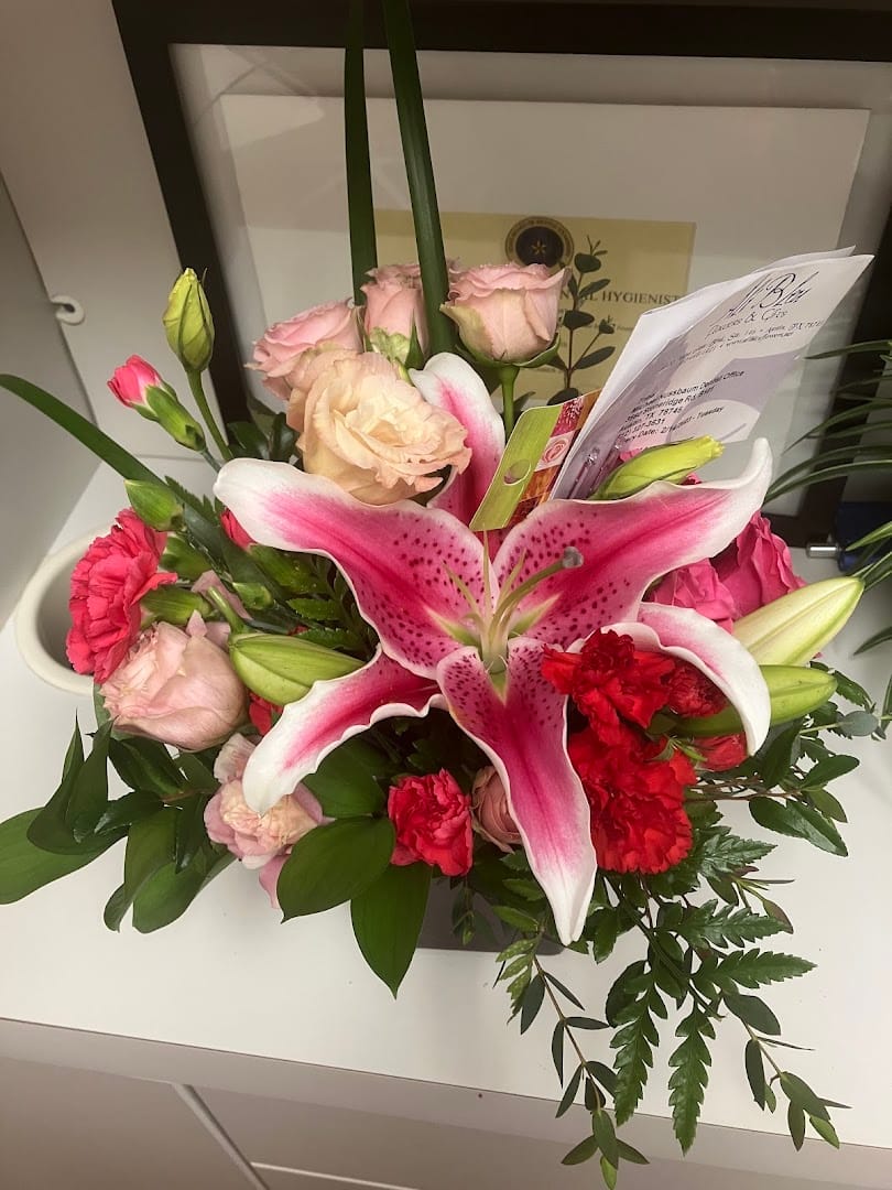 Flower arrangement featuring a large pink stargazing lily and roses